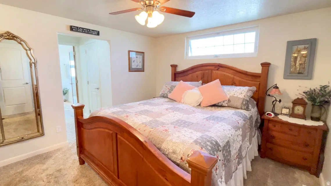 Bedroom featuring a ceiling fan and light colored carpet