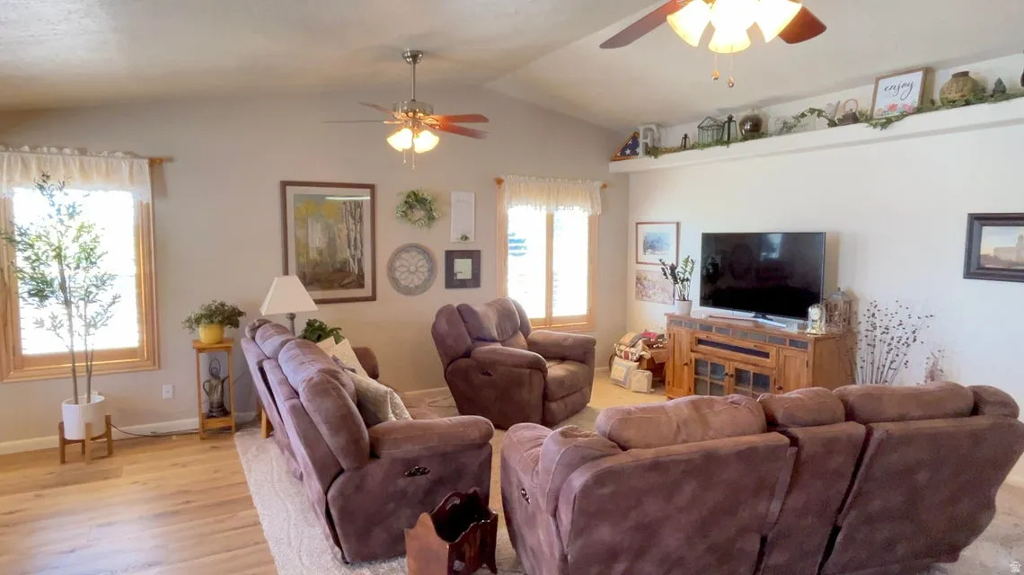 Living room featuring ceiling fan and light wood-style floors