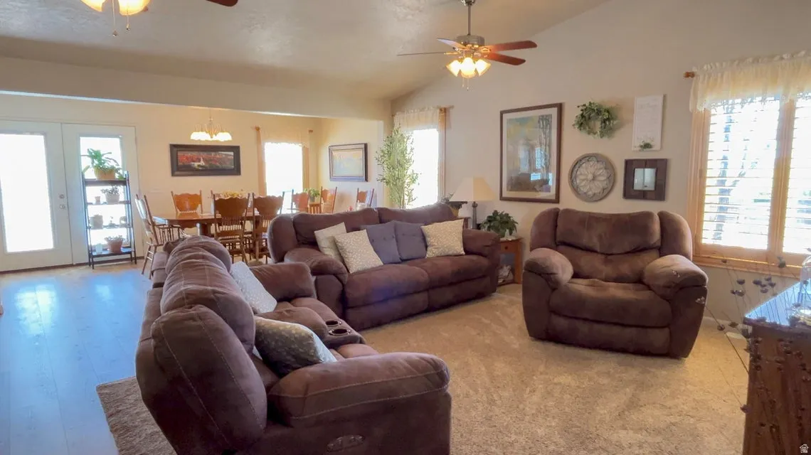 Living area with ceiling fan, french doors, and vaulted ceiling