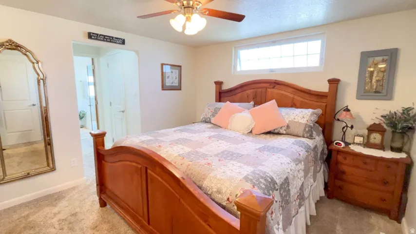 Bedroom featuring a ceiling fan and light colored carpet
