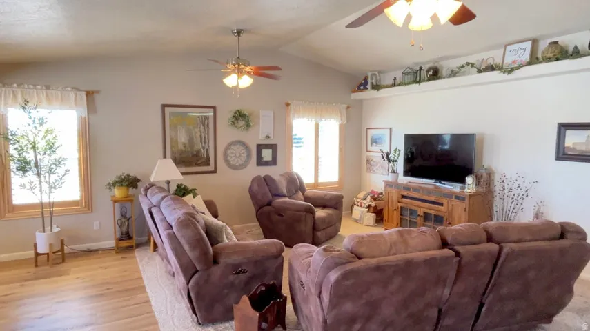Living room featuring ceiling fan and light wood-style floors