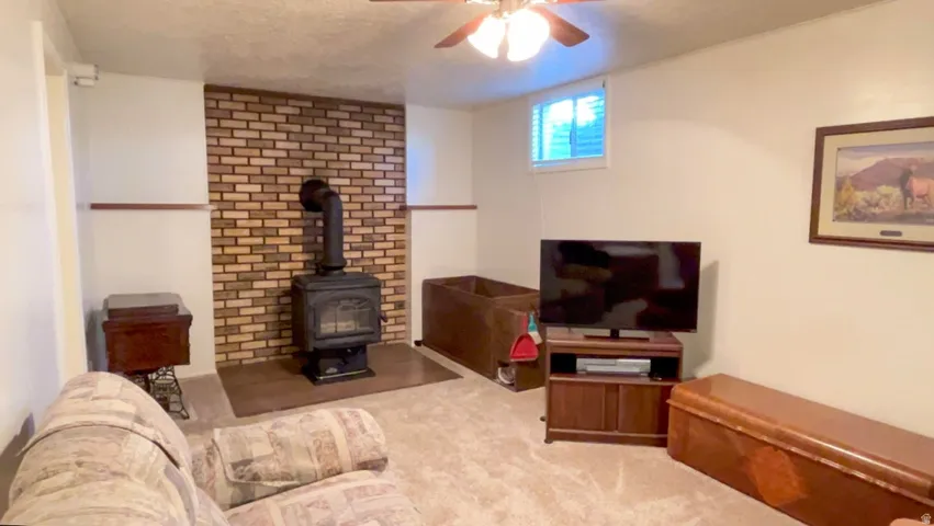 Carpeted living area featuring a wood stove