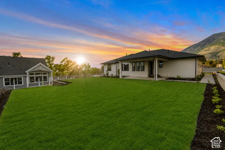 Expansive manicured lawn with a contemporary ranch-style residence and a separate gabled structure