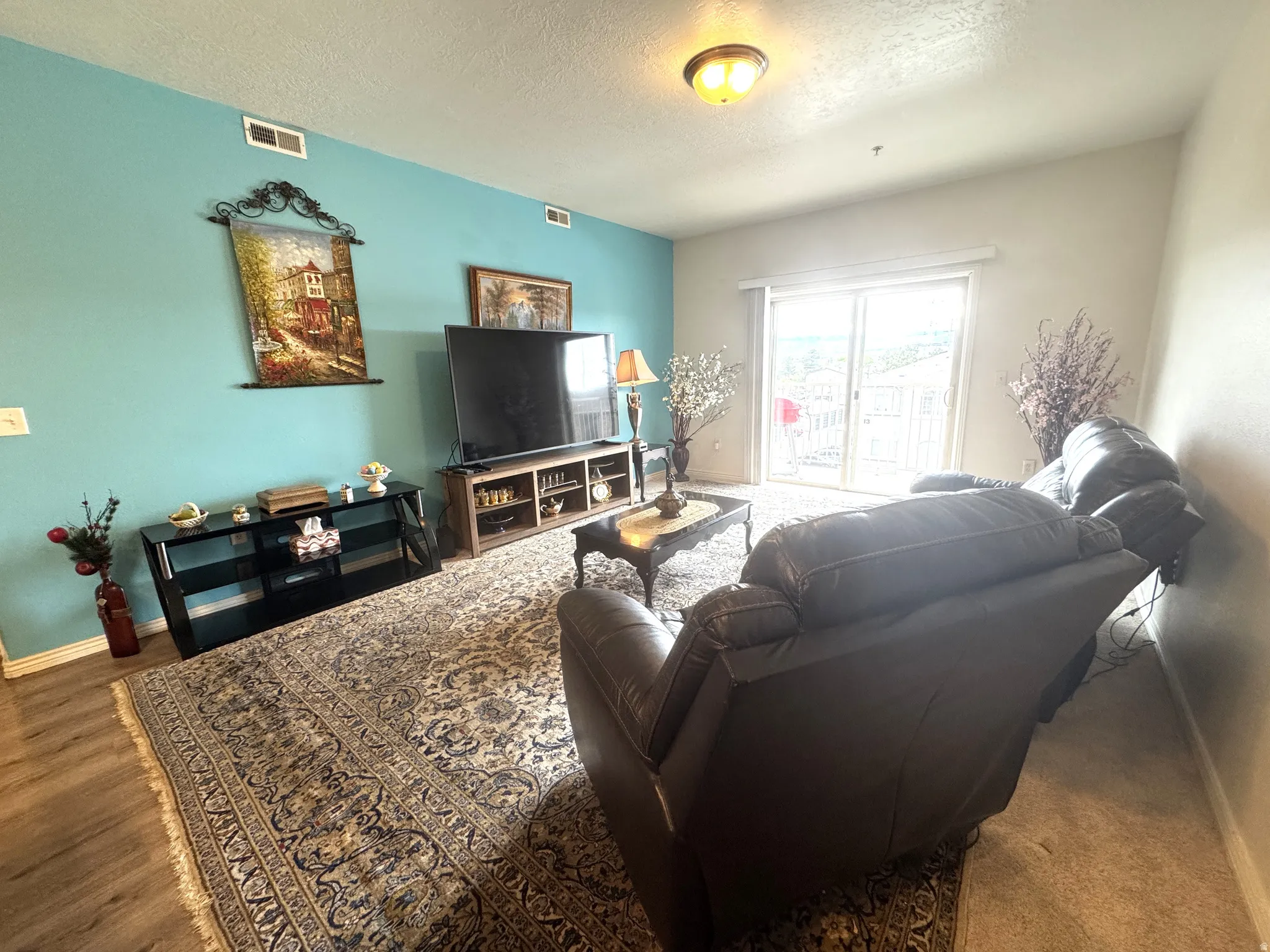 Living room featuring baseboards and a textured ceiling