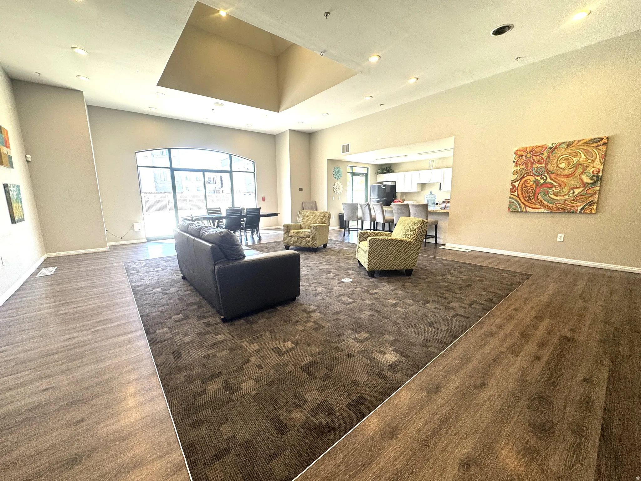 Living room with dark wood-type flooring, recessed lighting, and a high ceiling