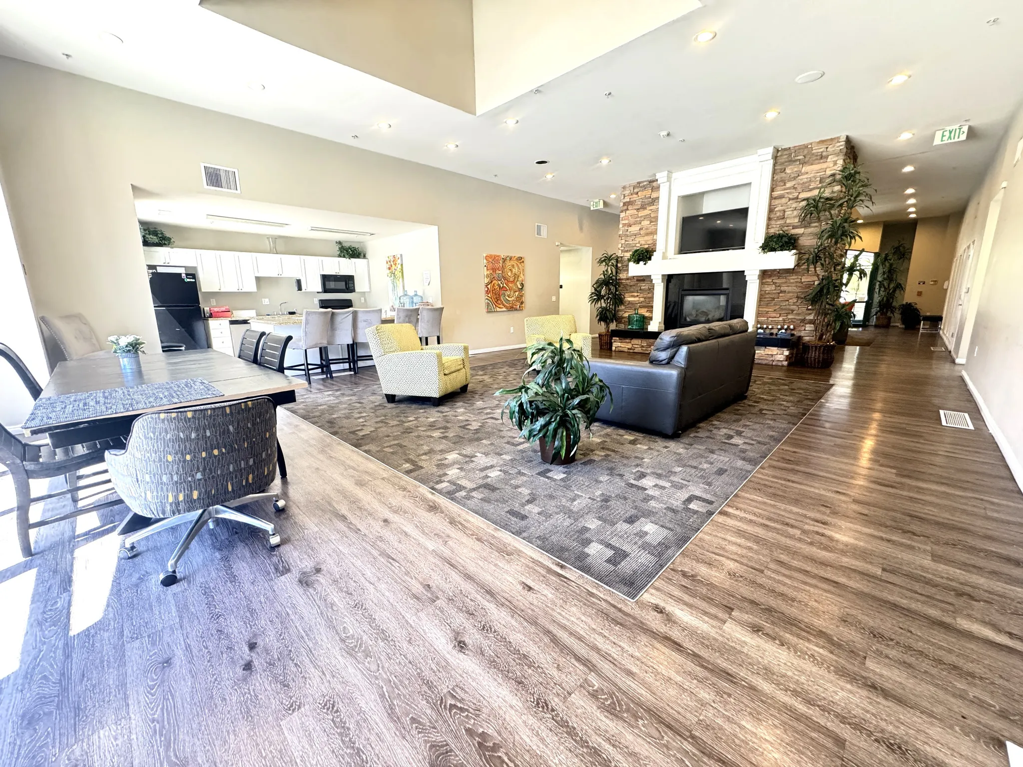Club house living room featuring recessed lighting, wood finished floors, and a stone fireplace