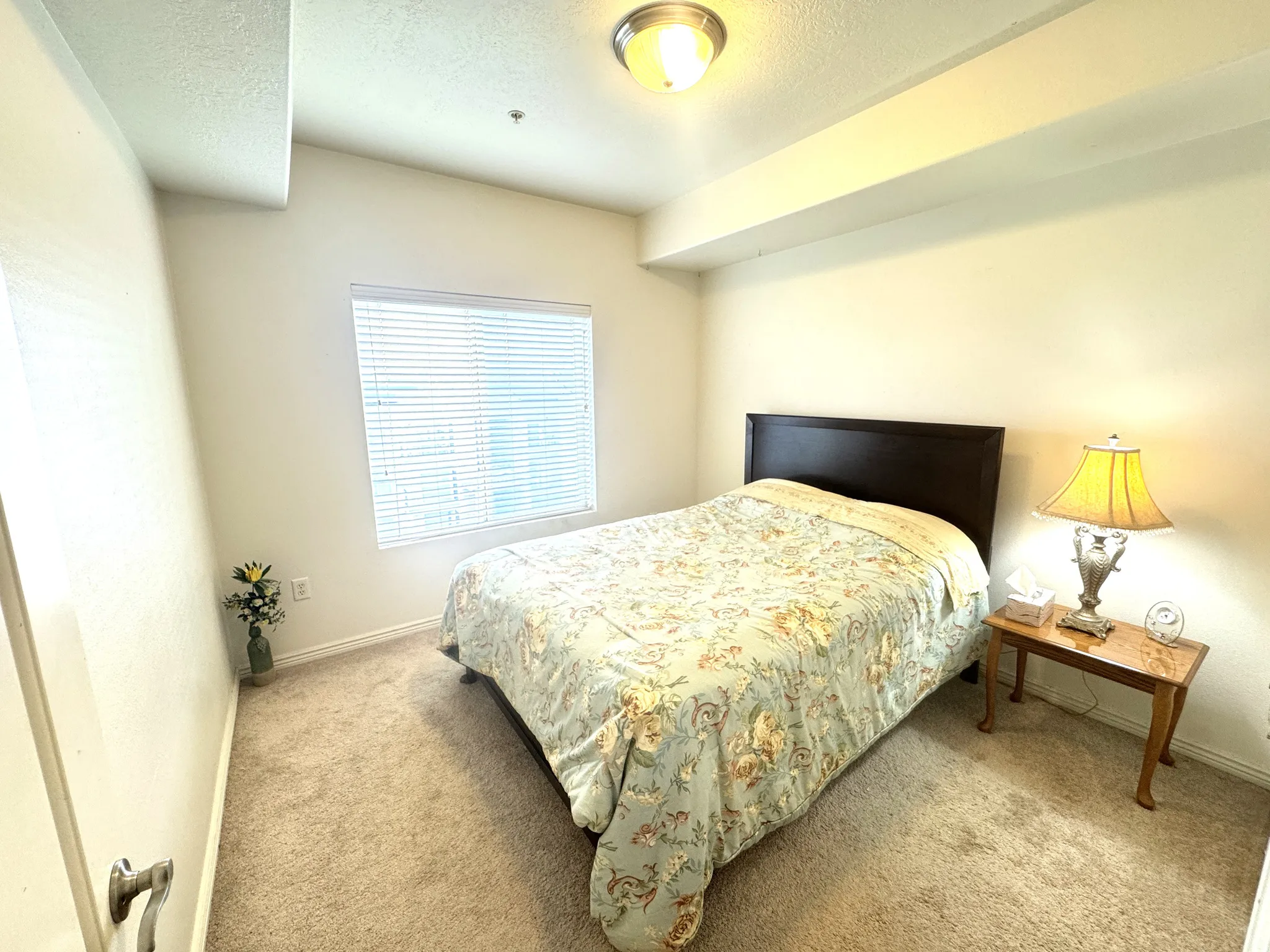 Carpeted bedroom with a textured ceiling and baseboards