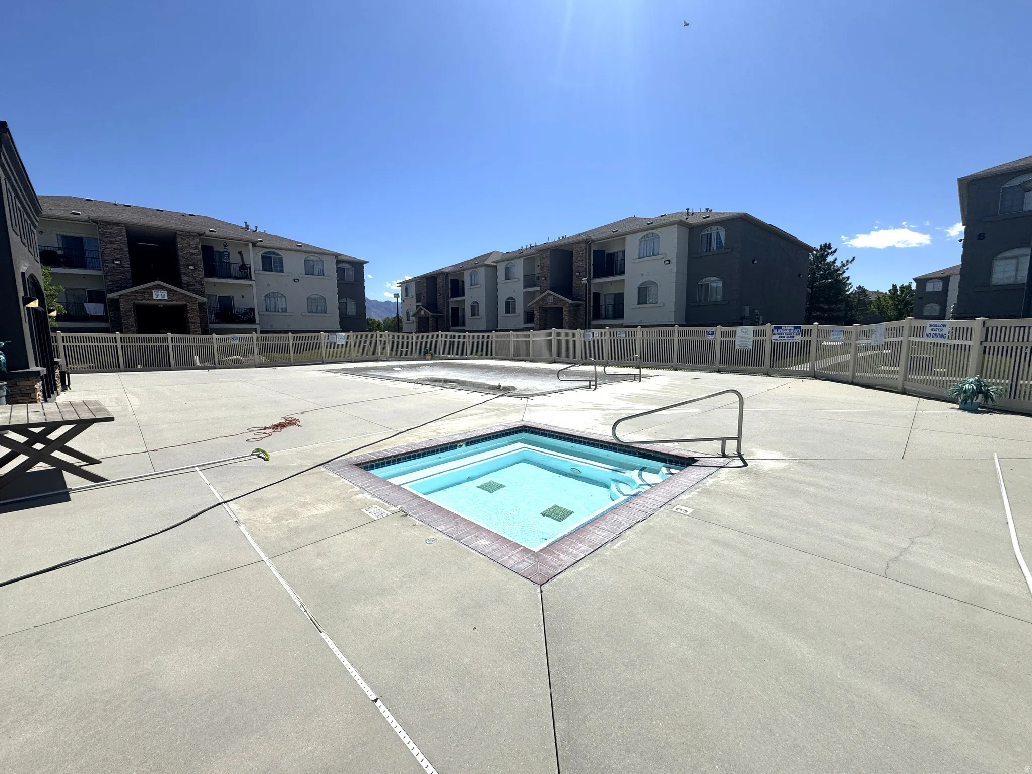 Community pool featuring a hot tub, a residential view, and a patio