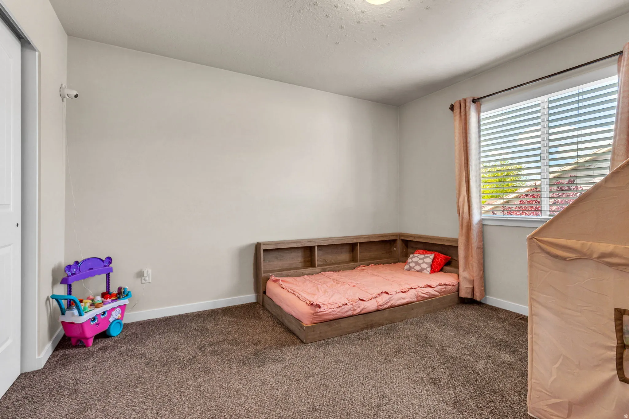 Bedroom with dark colored carpet and a textured ceiling