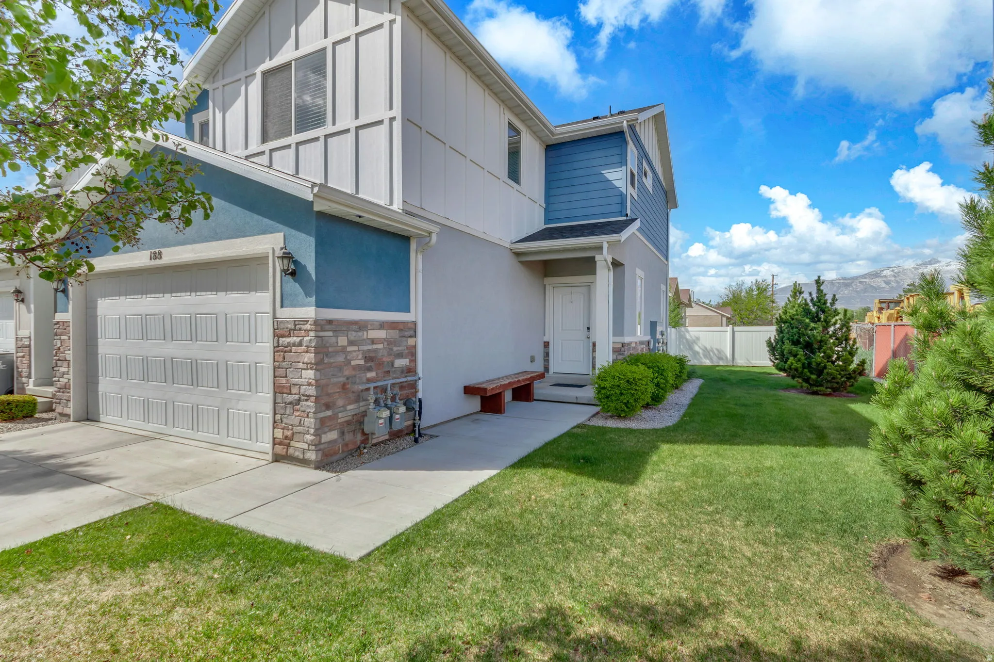 View of front of house with stone siding, concrete driveway, stucco siding, and a mountain view