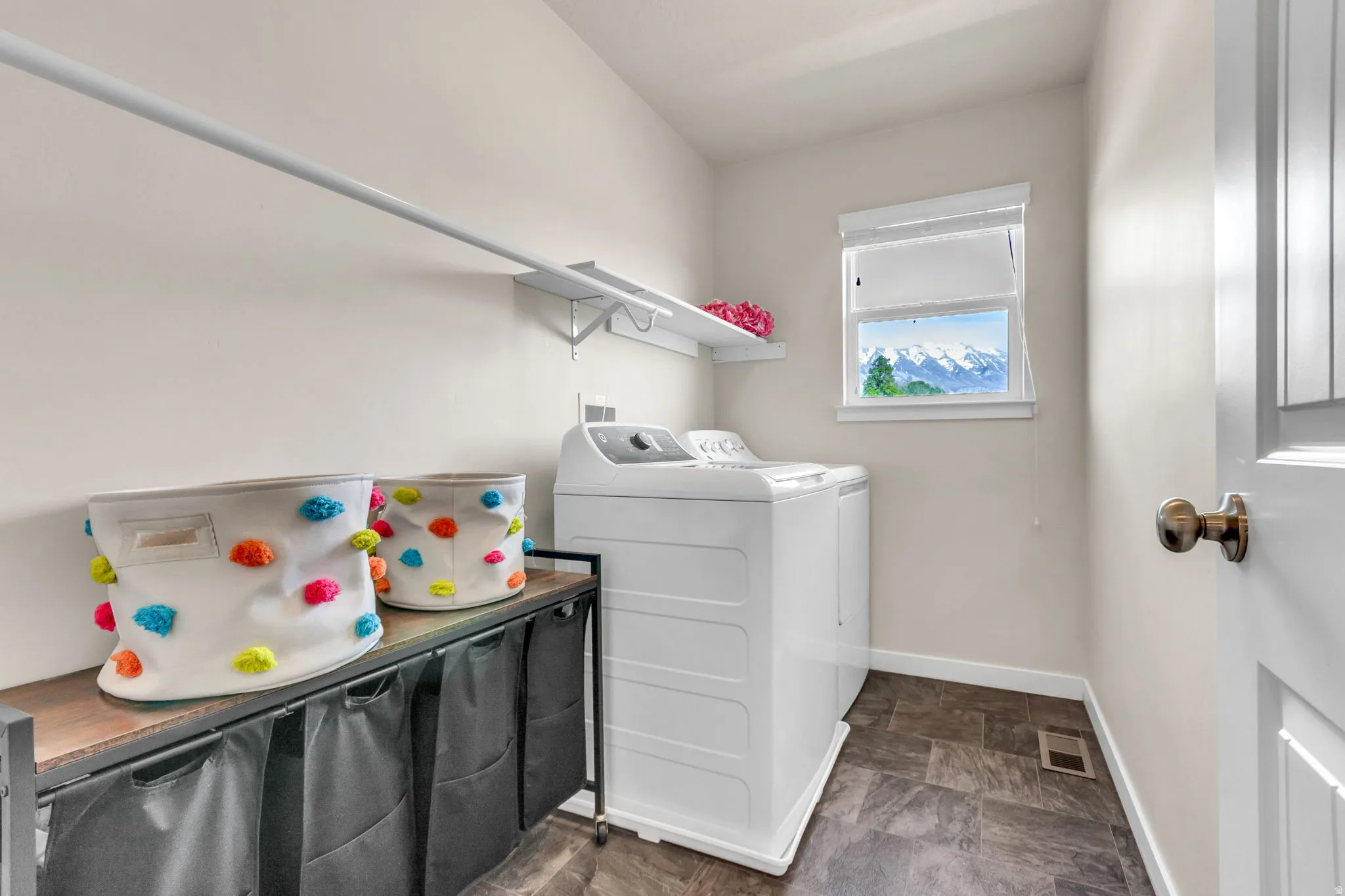 Laundry room featuring stone finish flooring and washing machine and dryer