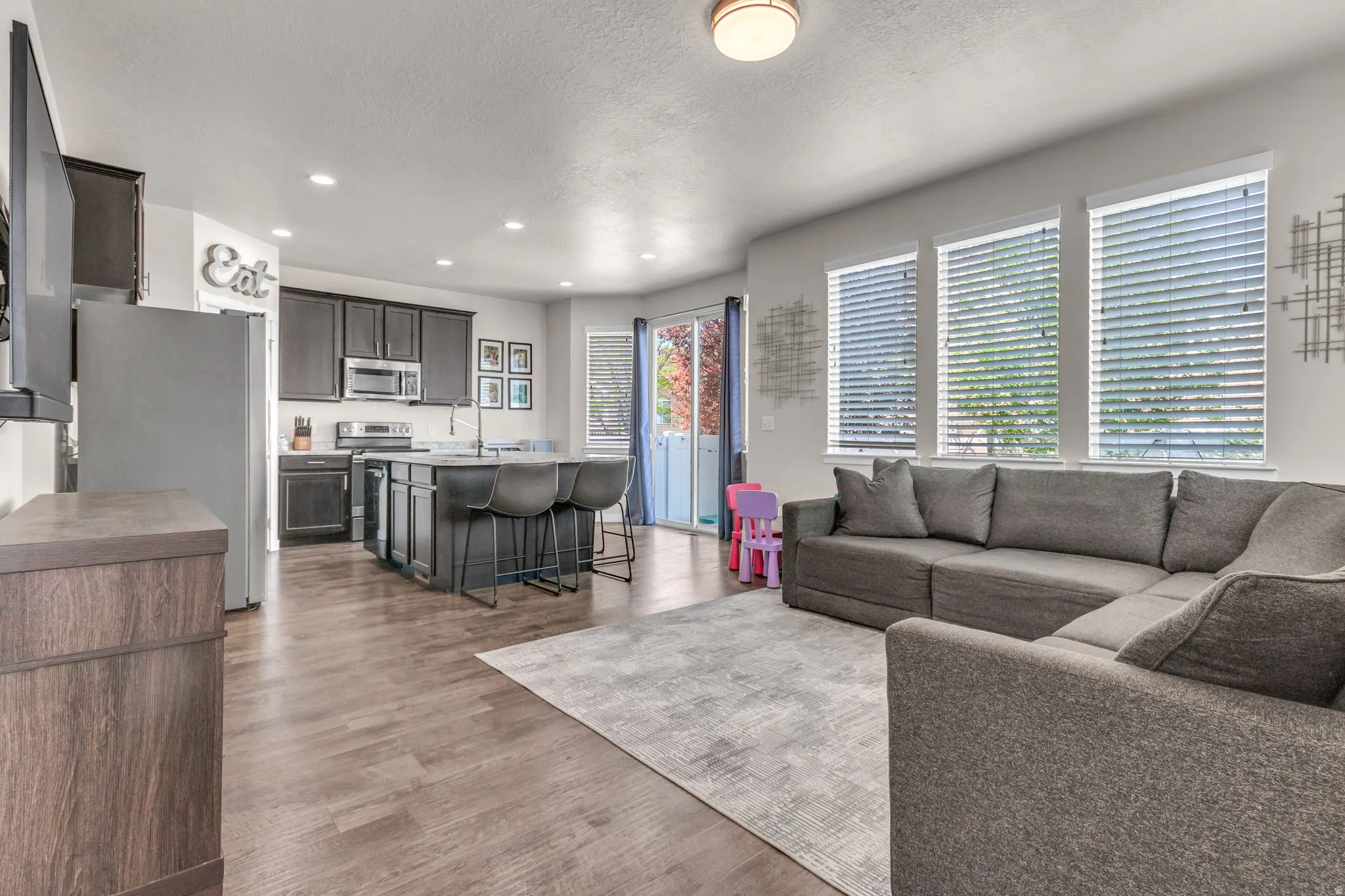 Living area featuring dark wood-style floors, recessed lighting, and a textured ceiling
