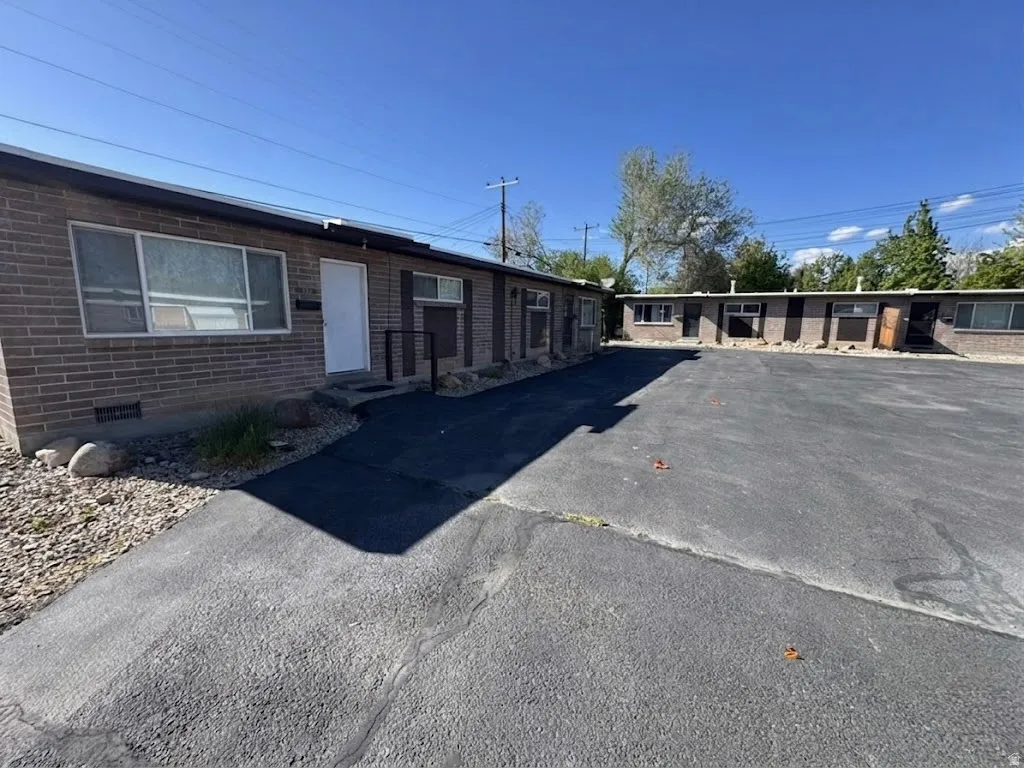 View of front of home featuring brick siding, crawl space, and driveway