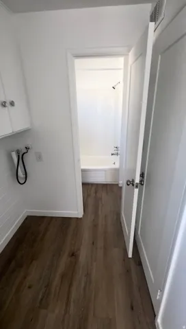 Hall featuring dark wood finished floors and baseboards
