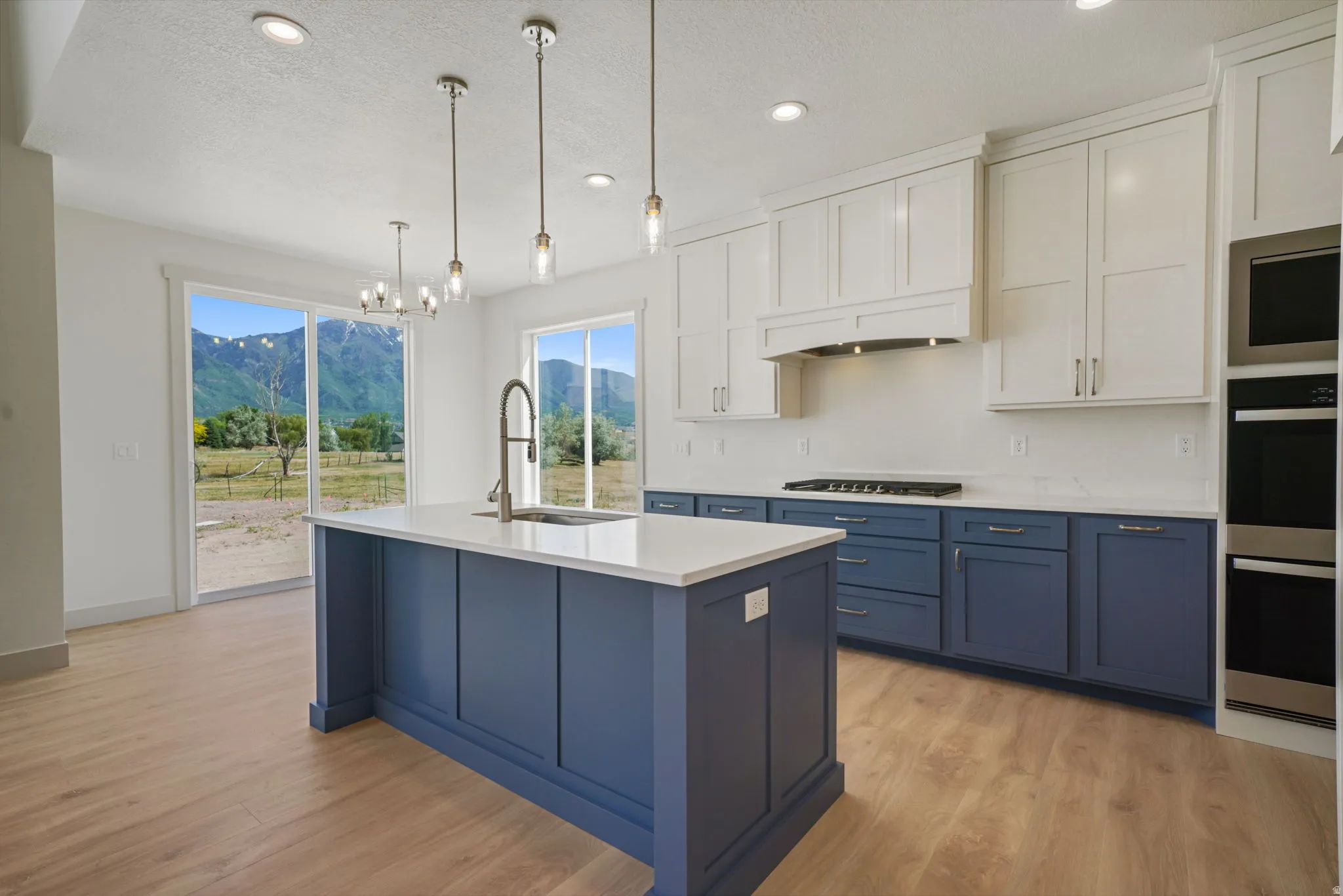 Modern kitchen featuring a blue island with a built-in sink and gooseneck faucet