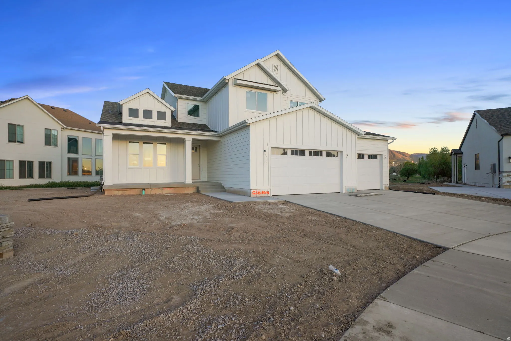 Modern farmhouse featuring board and batten siding, an attached garage, concrete driveway, and a shingled roof