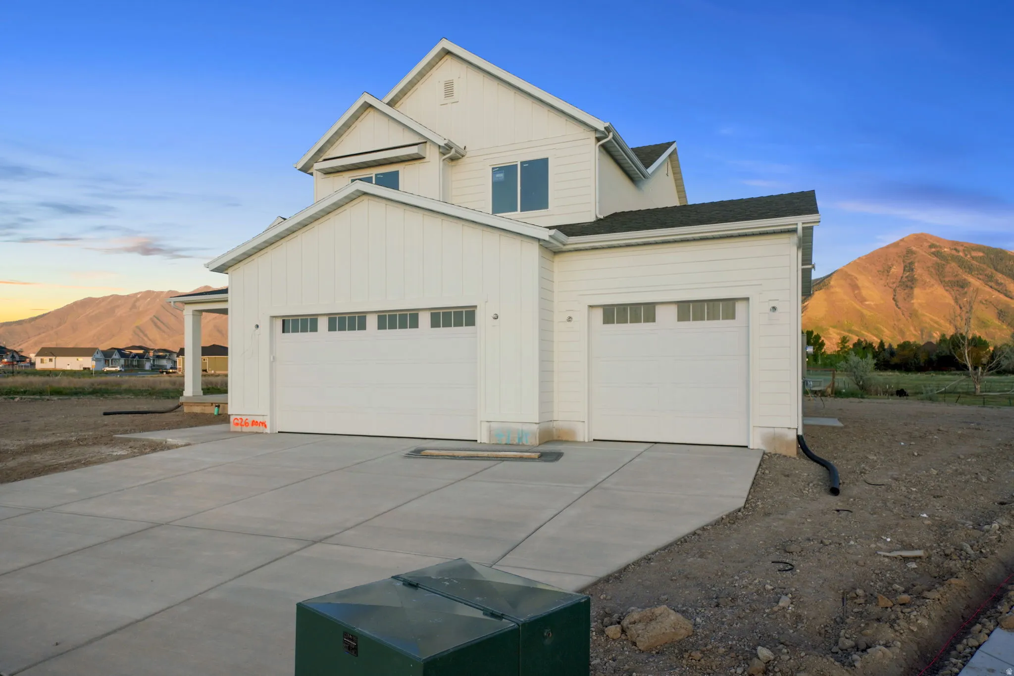 View of front facade with a mountain view, concrete driveway, a garage, and board and batten siding