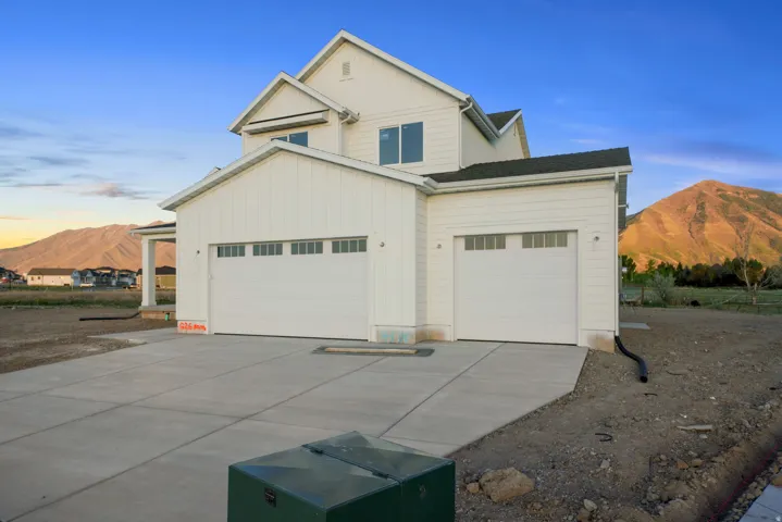 View of front facade with a mountain view, concrete driveway, a garage, and board and batten siding