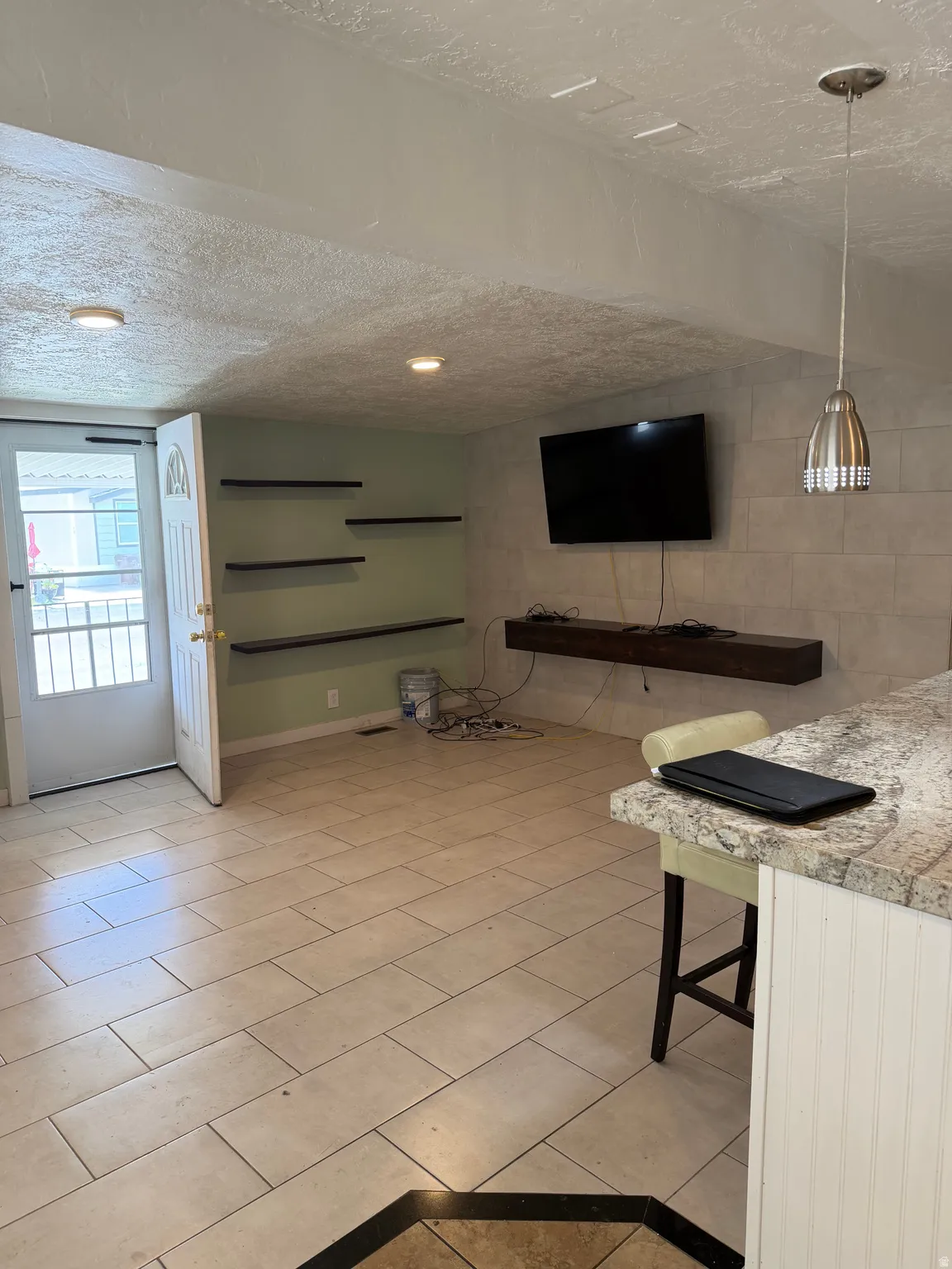 Living room with light tile patterned floors and a textured ceiling