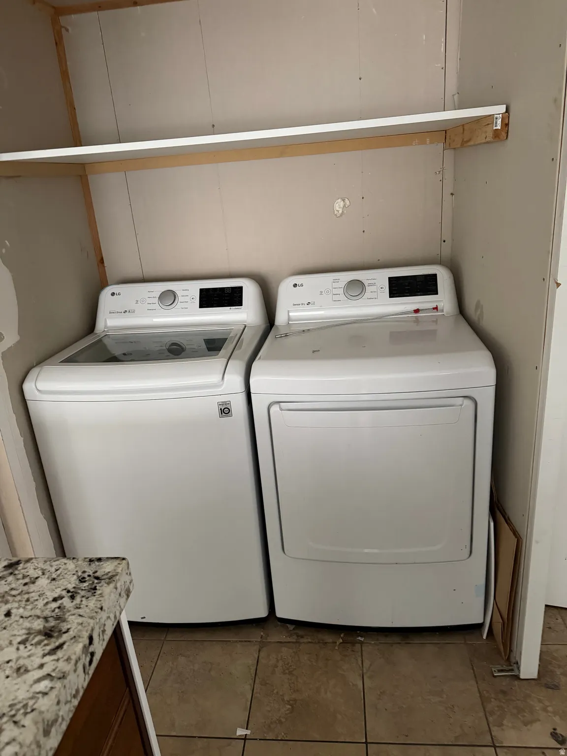 Laundry area with washer and dryer and dark tile patterned floors
