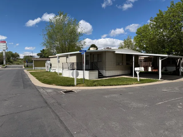 Manufactured / mobile home with an attached carport and a front lawn