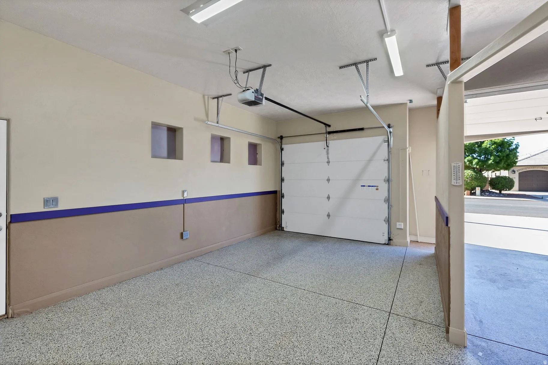 Garage with baseboards and a garage door opener