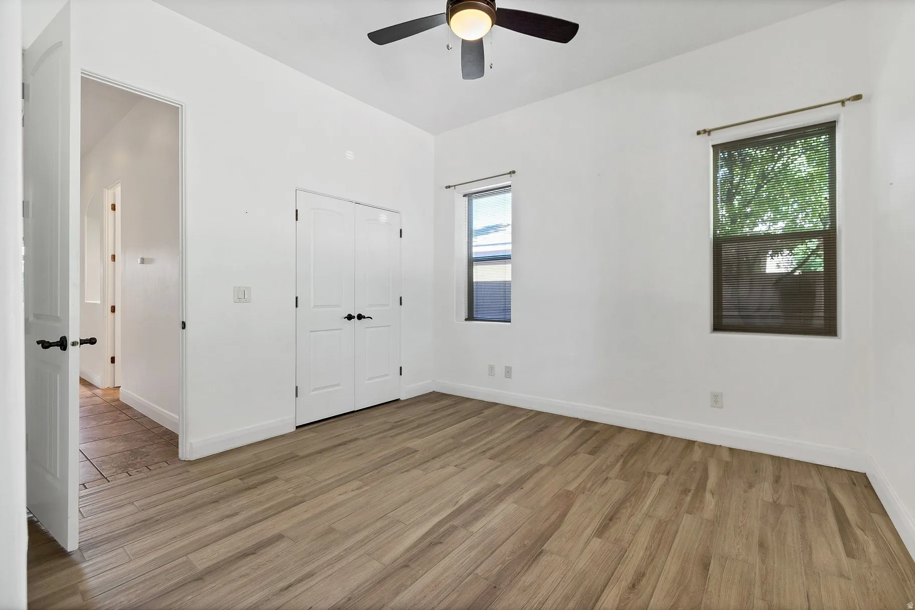 Unfurnished bedroom with light wood-style flooring, a closet, and ceiling fan
