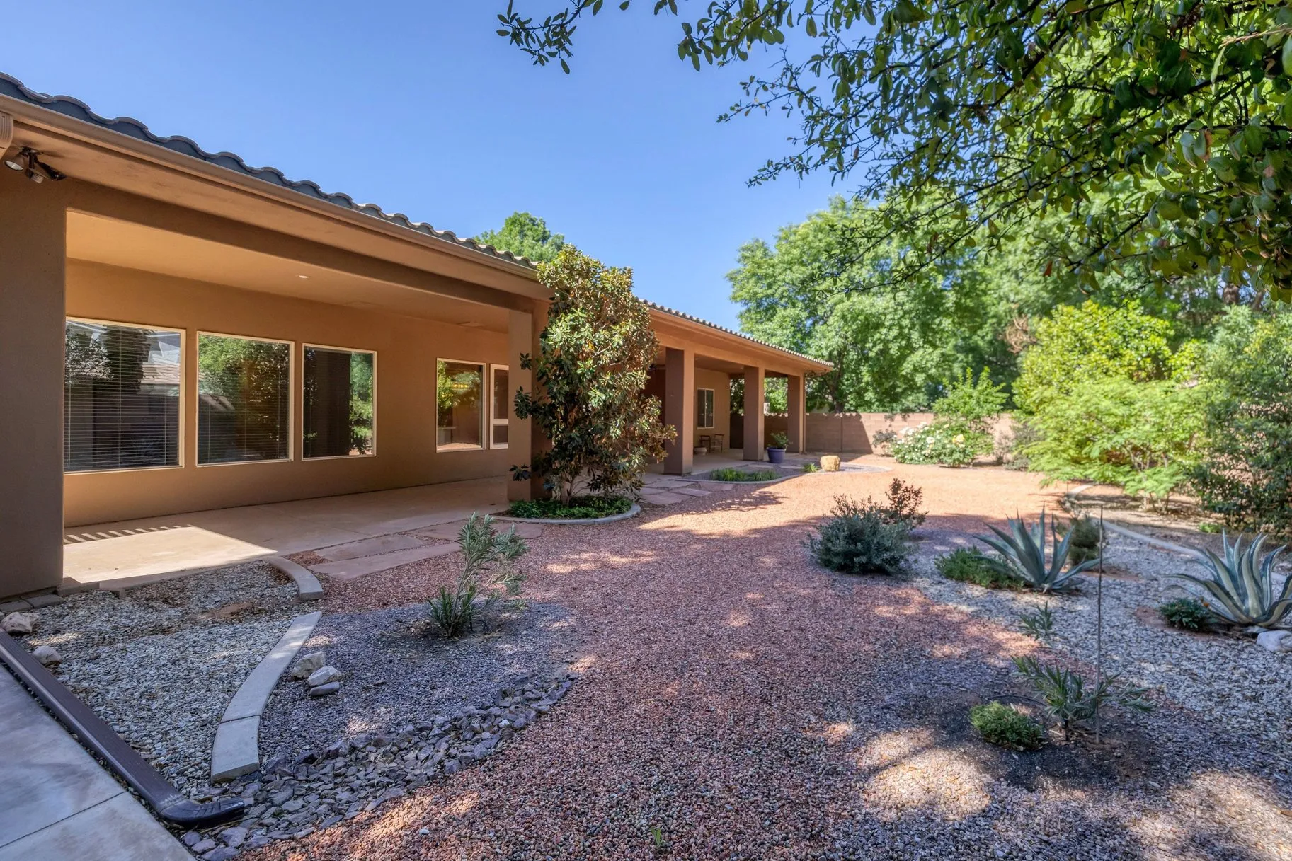 Rear view of house with a patio area, stucco siding, and a tile roof