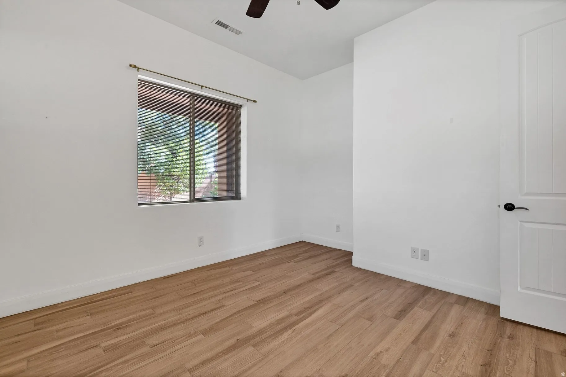 Unfurnished room with light wood-type flooring and ceiling fan
