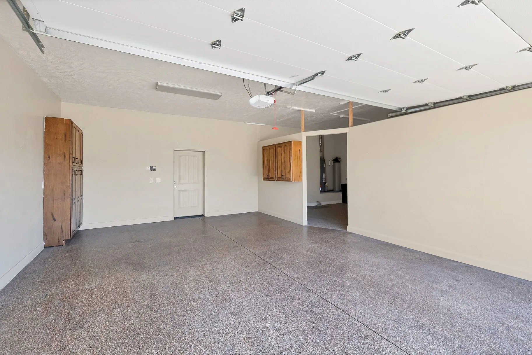 Garage with baseboards and a garage door opener