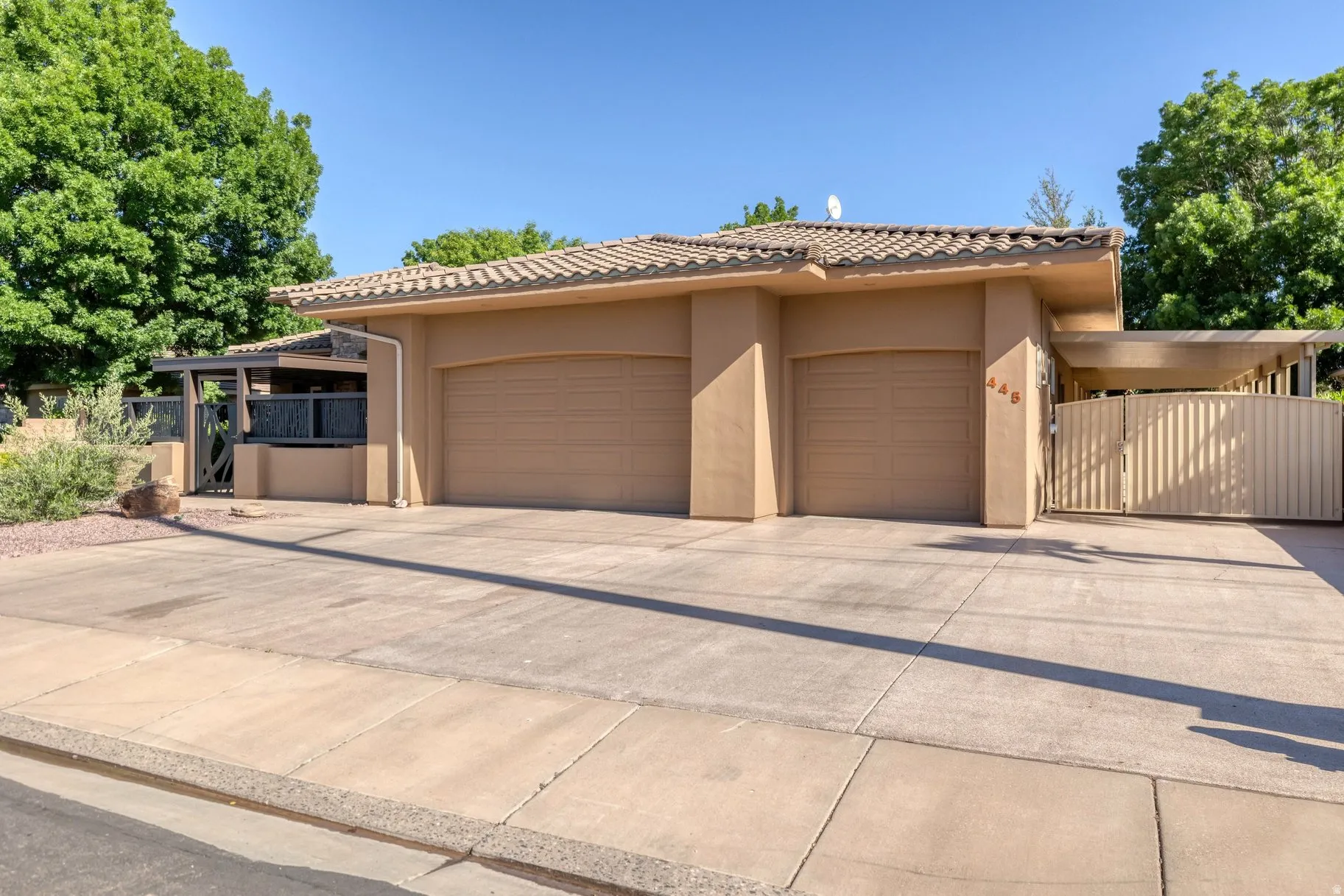 Mediterranean / spanish-style home featuring an attached garage, a tile roof, stucco siding, and concrete driveway