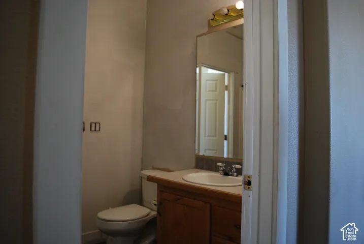 Bathroom vanity with an integrated sink, wood-finish cabinetry, and a full-width mirror