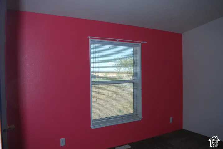 Interior space featuring a window with white blinds, a white window frame, and a vibrant red accent wall
