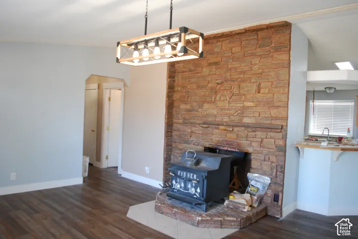 Stone-accented fireplace featuring a wood-burning stove and hearth