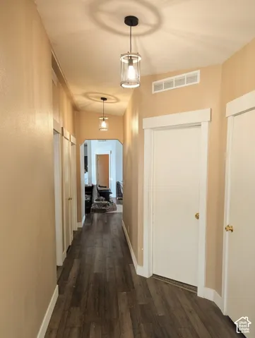 Hallway featuring dark wood finished floors and arched walkways