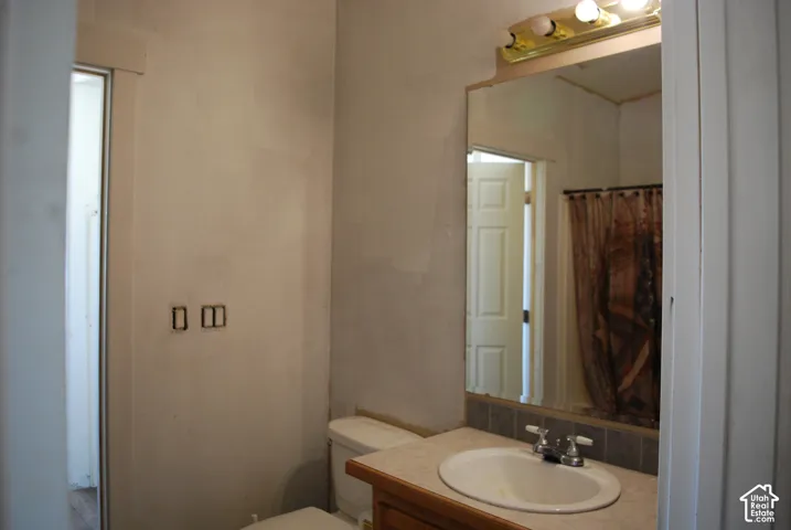 Bathroom vanity with an integrated sink, dual-handle faucet, and tiled backsplash