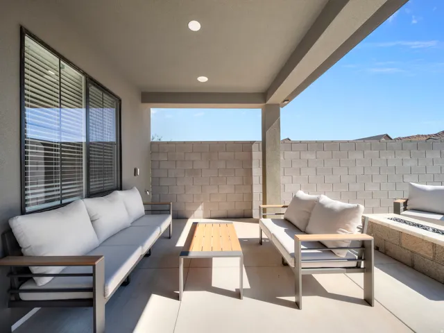 Covered patio with recessed lighting, large windows with blinds, built-in fire pit, and stucco exterior