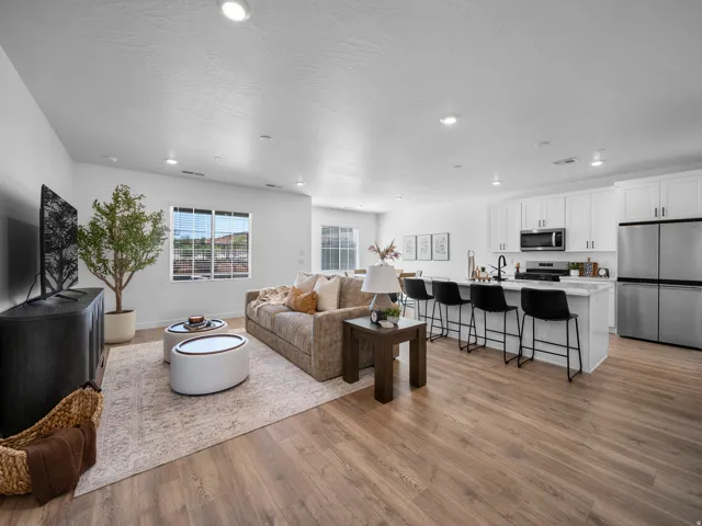 Open-concept living space featuring wood-finish flooring, recessed lighting, and white walls
