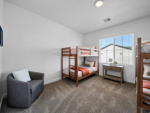 Carpeted room with a ceiling-mounted light fixture, white walls, and a large window with blinds