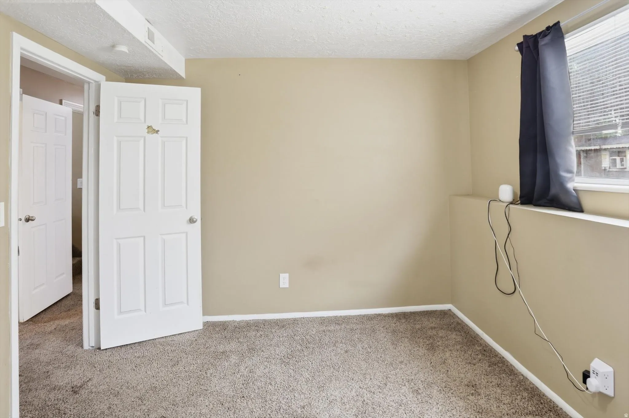 Bedroom with a textured ceiling and carpet