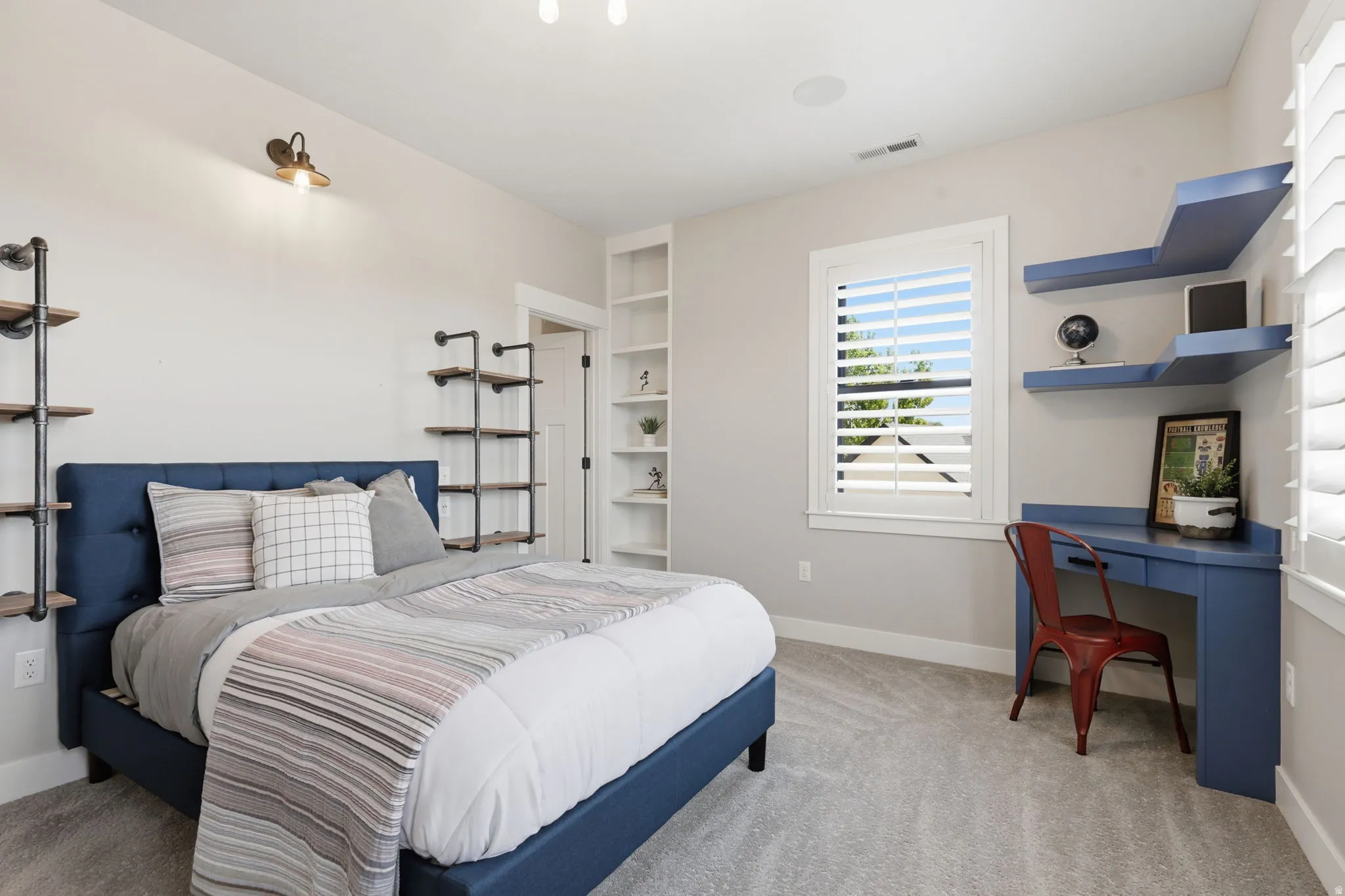 Bedroom with light carpet and a desk