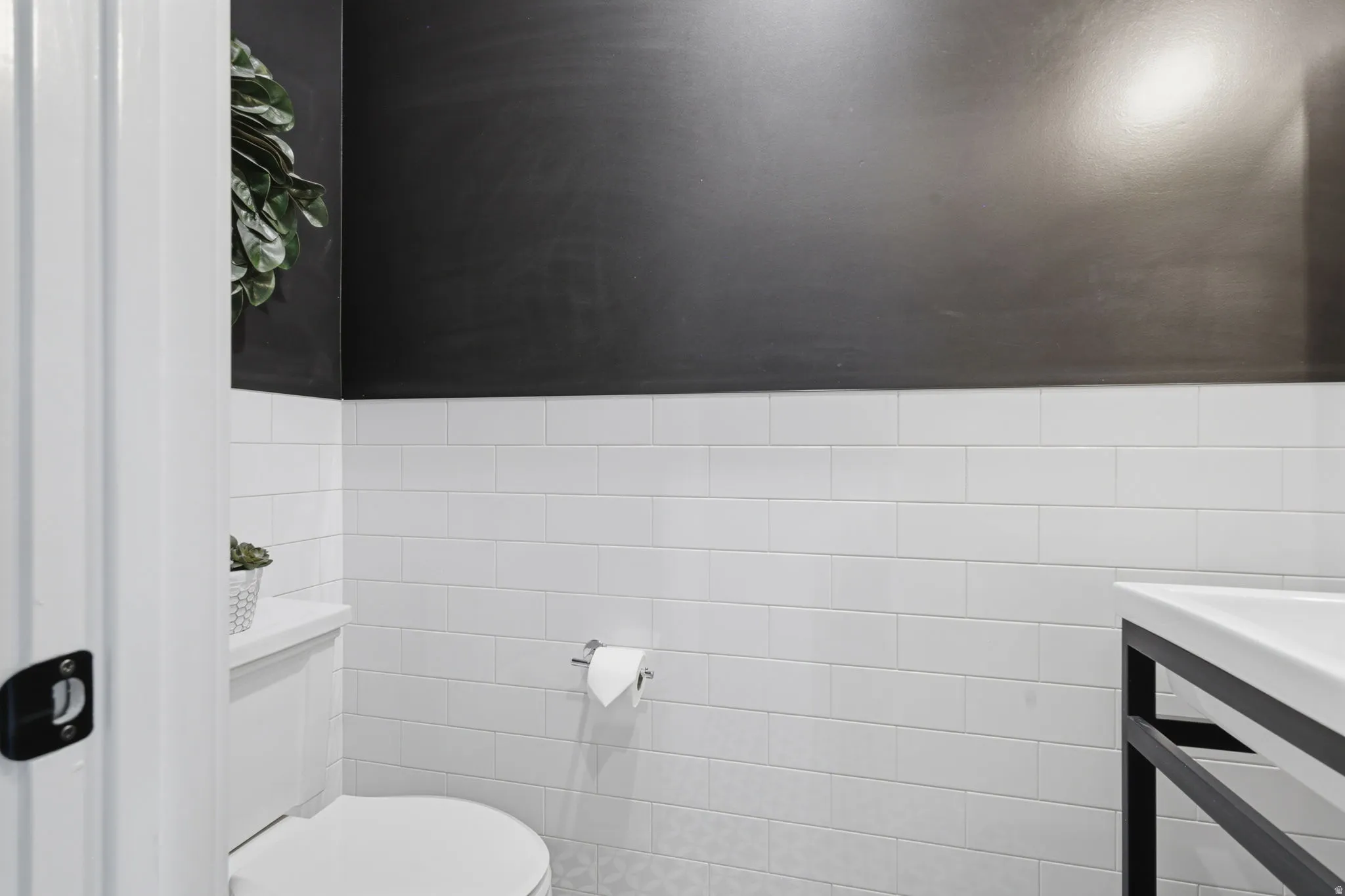 Bathroom with tile walls and wainscoting