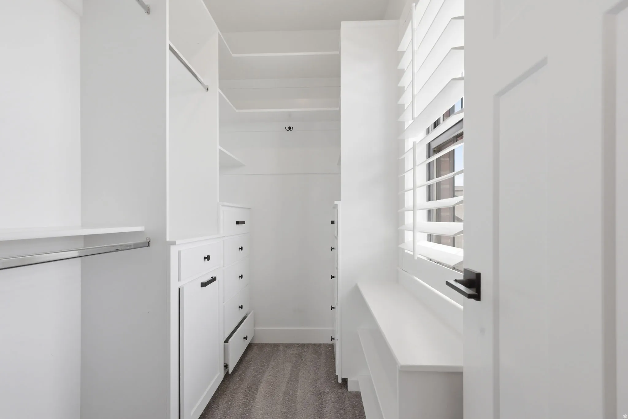 Walk in closet featuring dark carpet