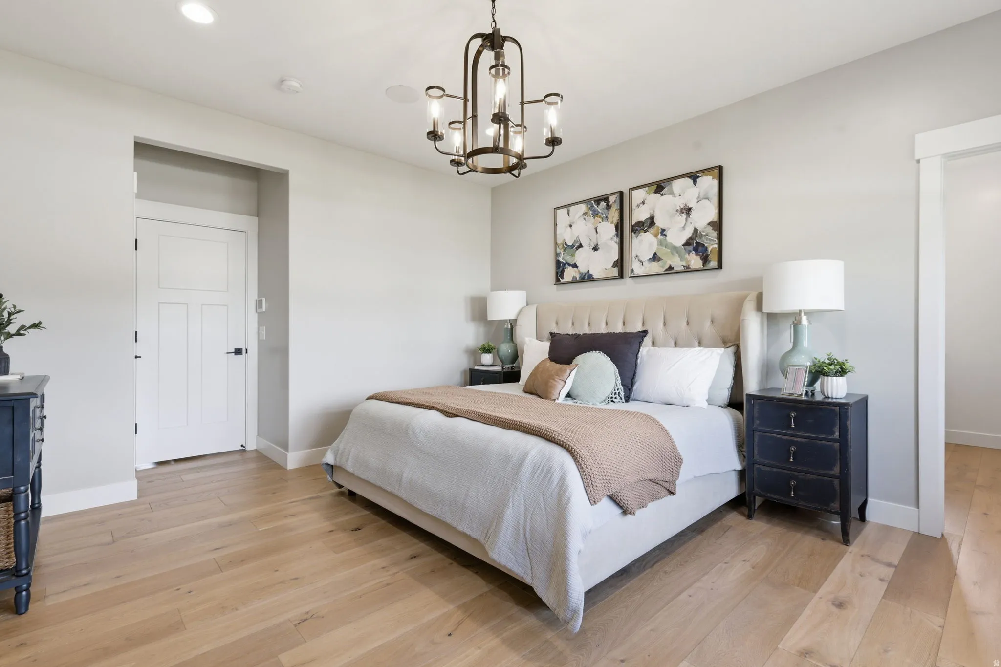 Bedroom with light wood-style flooring and suspended lighting