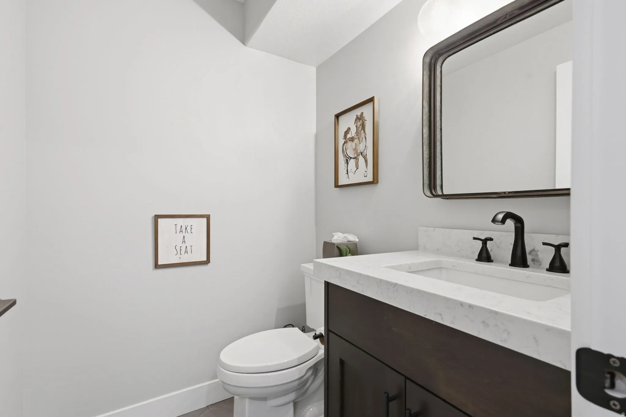 Half bathroom featuring vanity and toilet