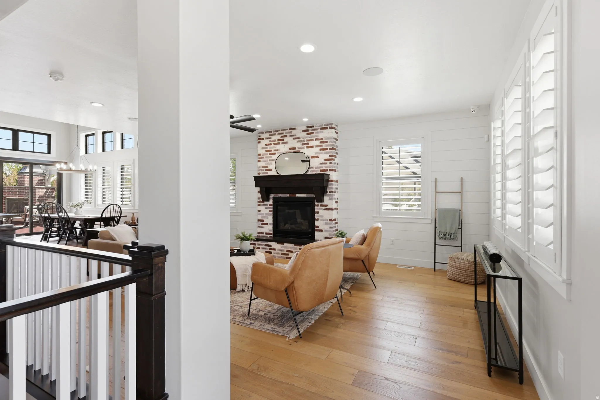 Living room with light wood finished floors, a fireplace, and recessed lighting