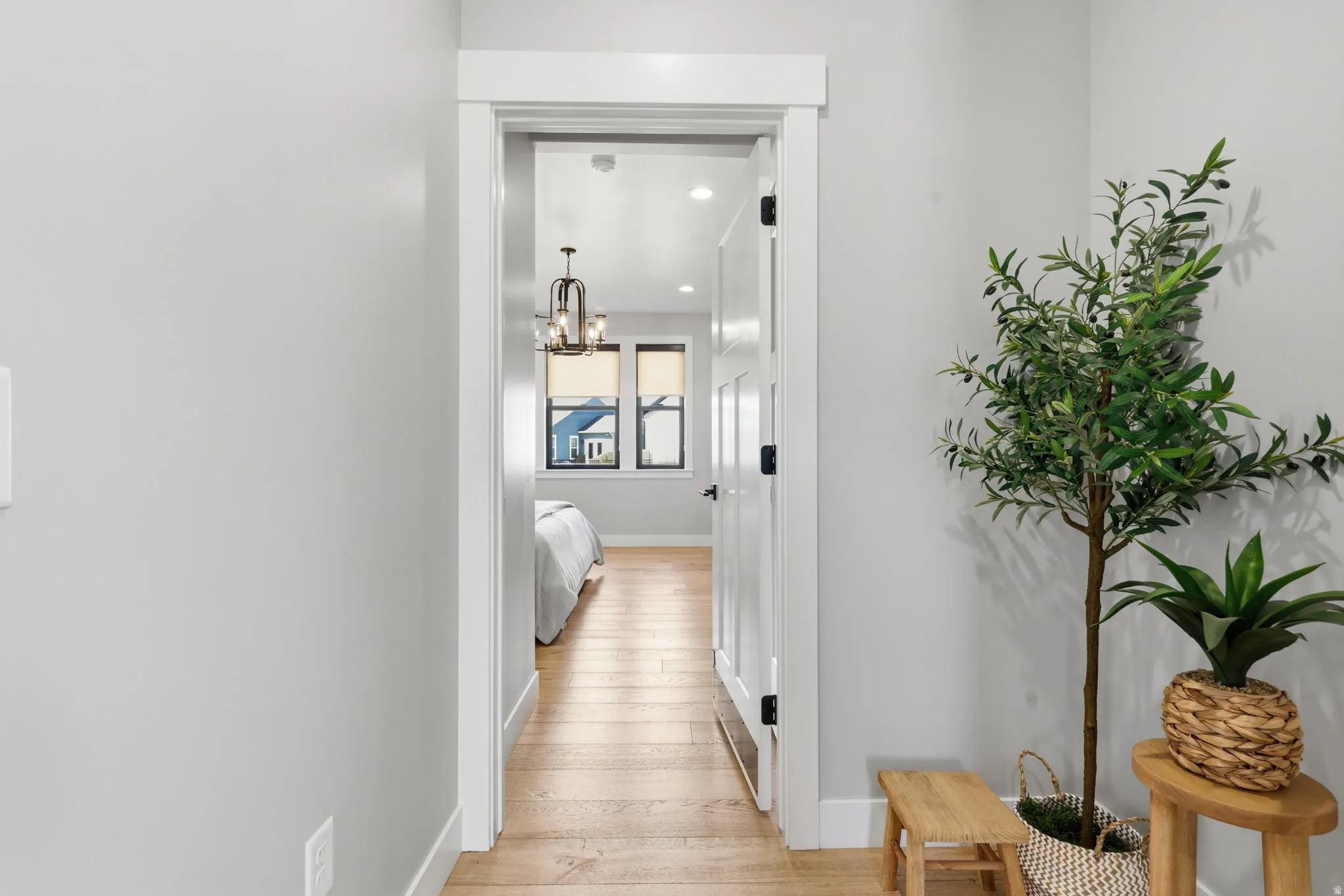 Hallway with hanging lights and light wood-style floors