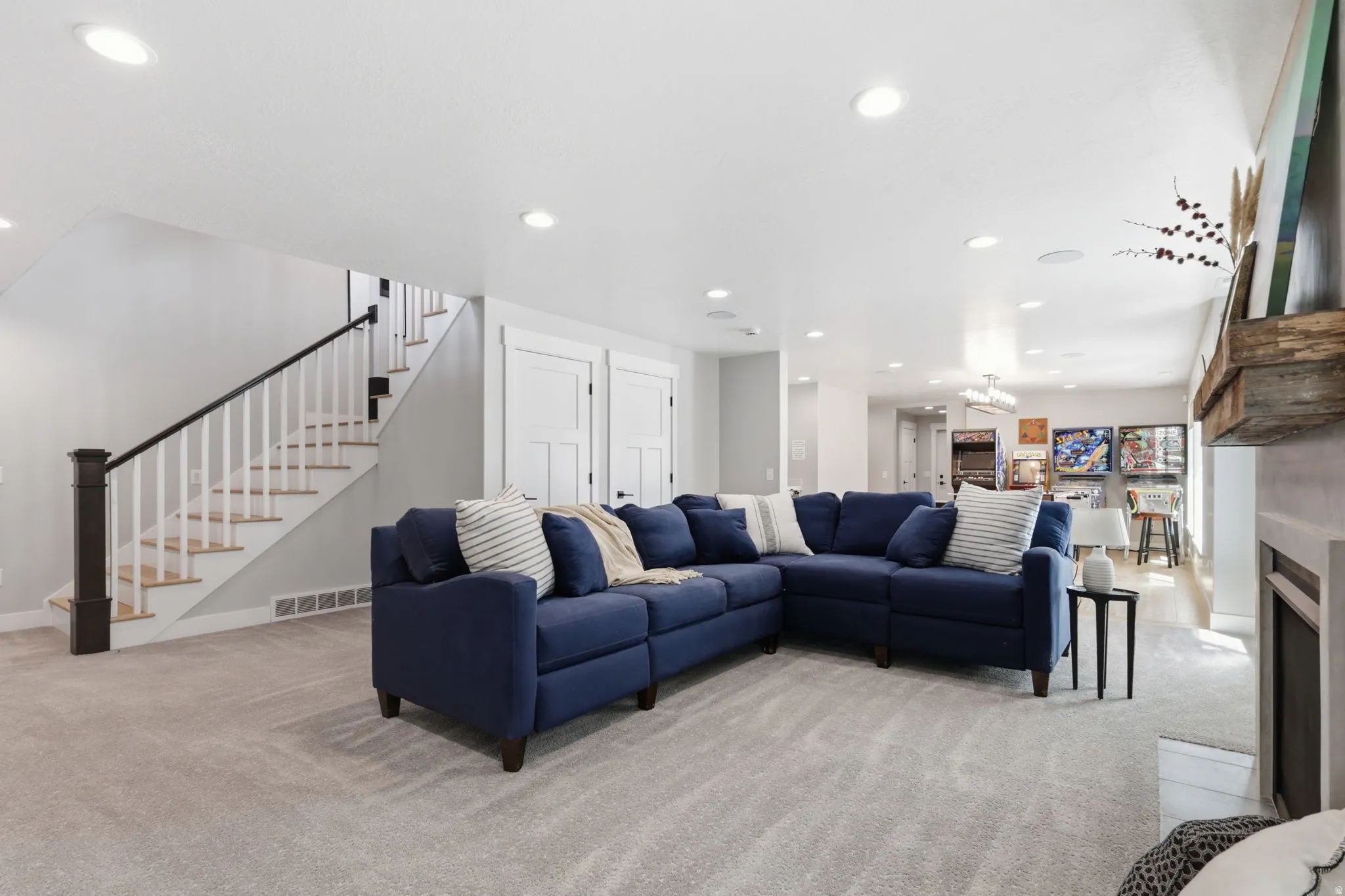 Living room with light carpet, a fireplace with flush hearth, and a chandelier