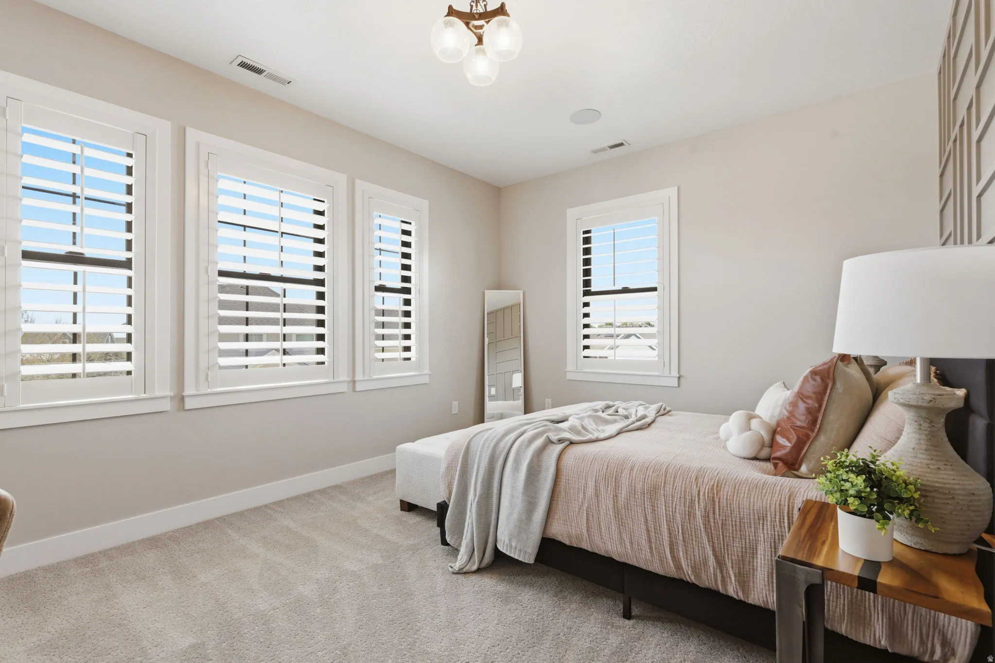Bedroom with light carpet and a chandelier