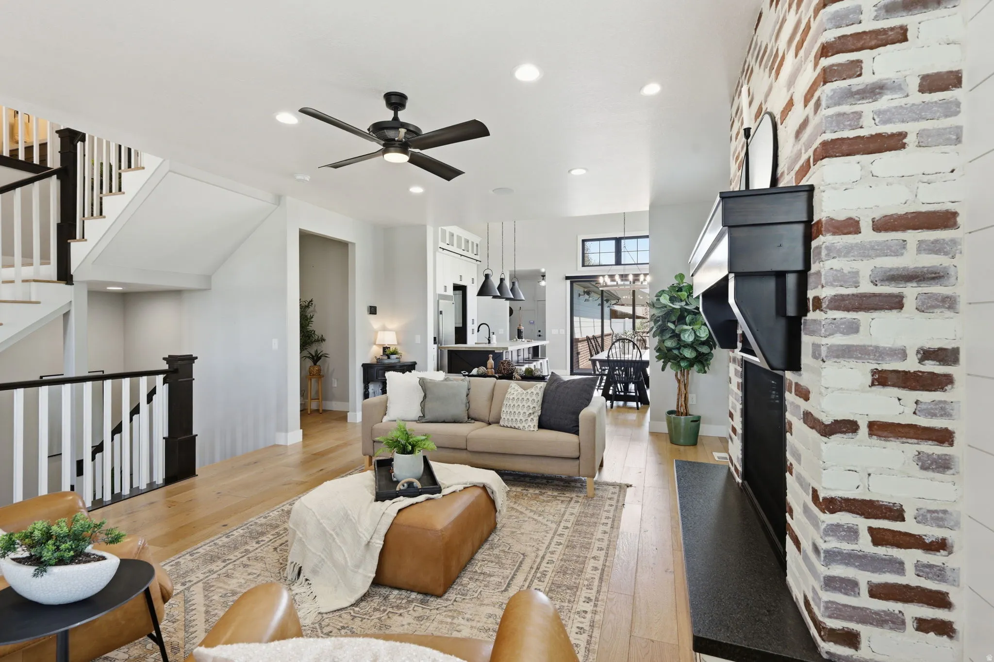 Living area with light wood-style flooring, a ceiling fan, and recessed lighting